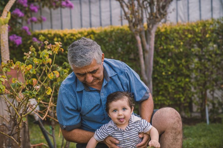 An older man with helping an infant walk in Norwich