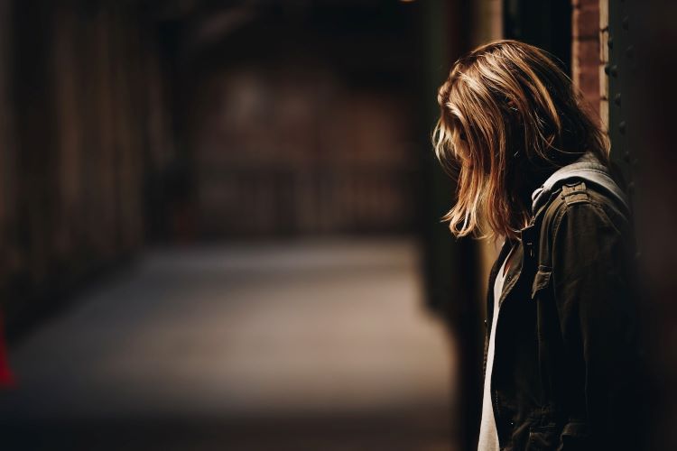 A woman looking down with her head hidden in Cambridge