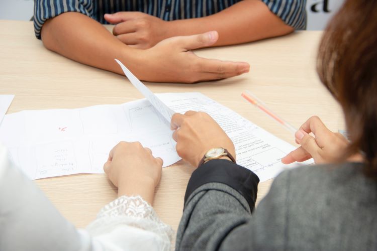 Patient and staff members looking through paperwork at a drug and alcohol rehab in Luton