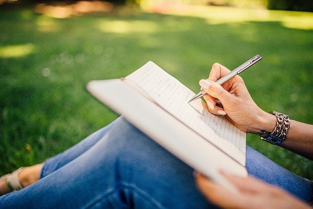 Patient taking notes in a garden at a drug and alcohol rehab centre in Derby