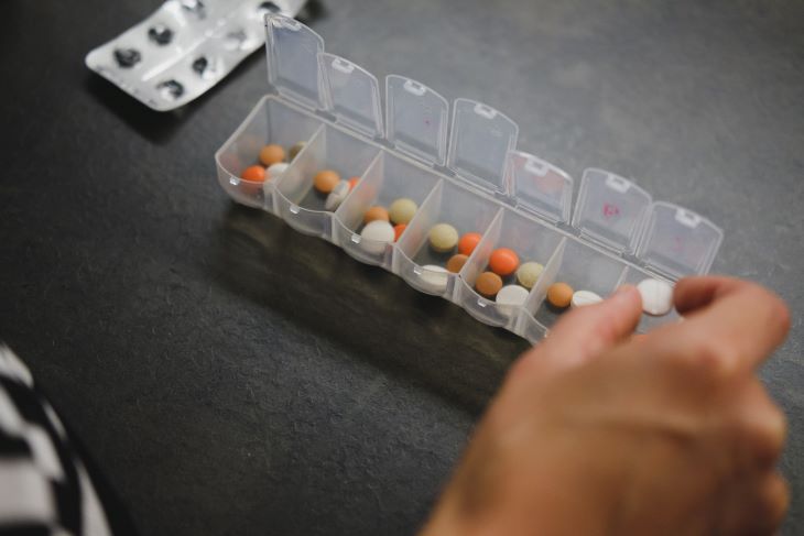 Person taking pills from a box at a drug and alcohol rehab in Luton