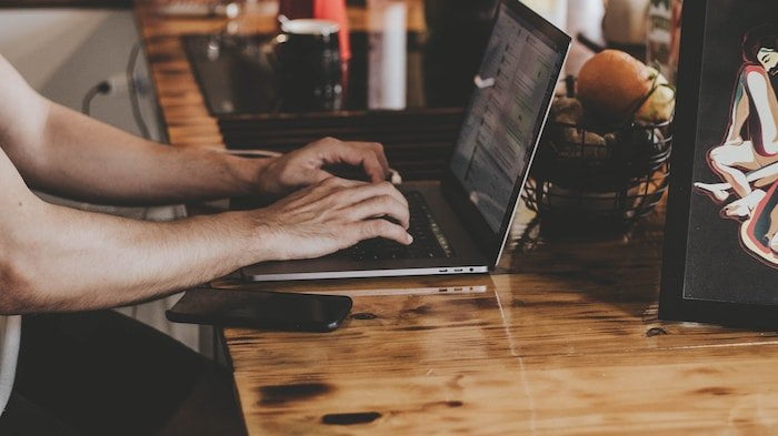 Person typing on a laptop at a drug and alcohol rehab centre in Devon