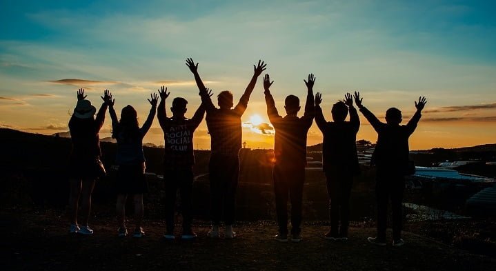 People standing together at sunset as part of an addiction support network