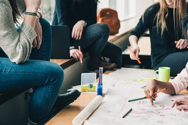 Support group sat together taking notes at a drug and alcohol rehab centre in Milton Keynes