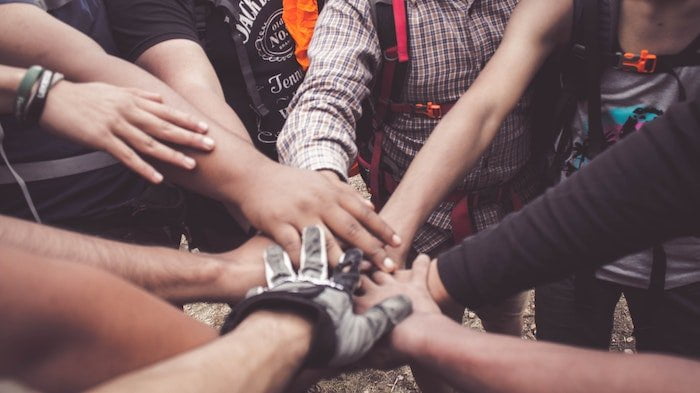 Support group stood with their hands together at a drug and alcohol rehab clinic in Luton