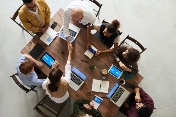 Support group working together on laptops at a drug and alcohol rehab in Norfolk