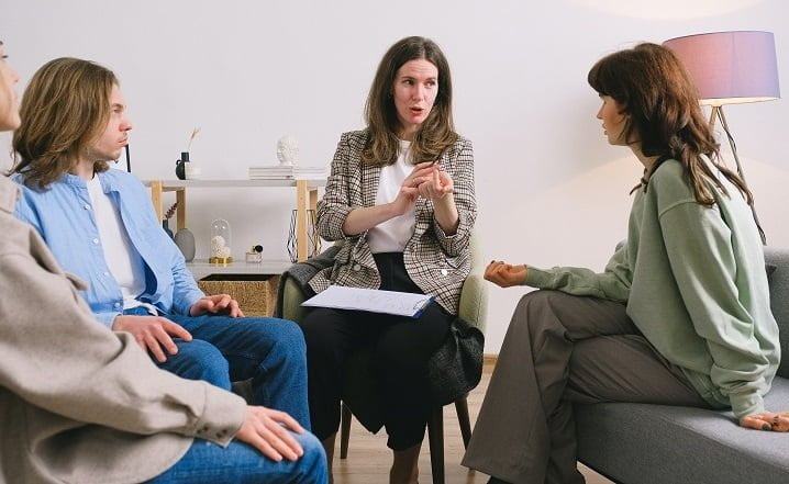 Therapist talking to patients at a drug and alcohol rehab clinic in Gloucestershire