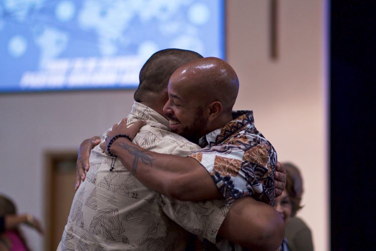 Two men embracing at a support group meeting in a drug and alcohol rehab in Norfolk