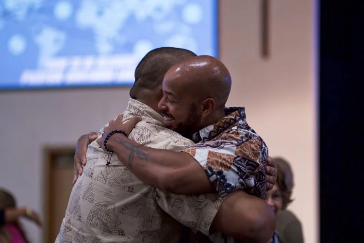 Two men embracing at a support group meeting in a drug and alcohol rehab in Norfolk