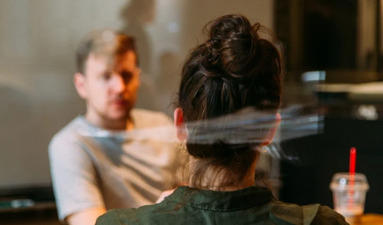 Two people having a serious conversation at a drug and alcohol rehab centre in Norfolk