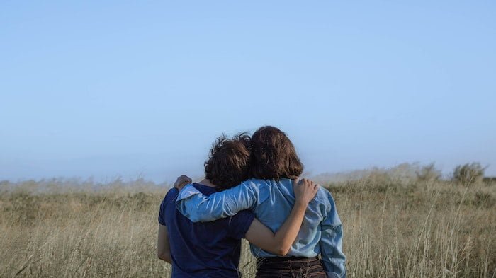Two people hugging in a field outside of a drug and alcohol rehab clinic in Durham