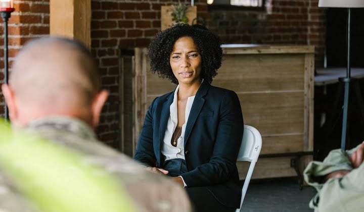 Woman leading group therapy at drug and alcohol rehab