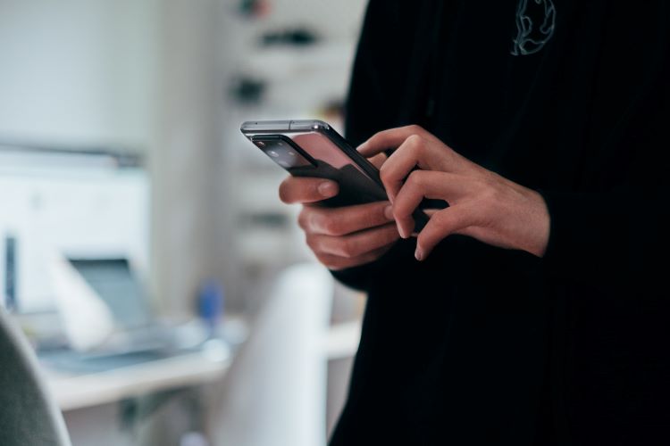 Woman typing on a phone at a drug and alcohol rehab in Lincolnshire