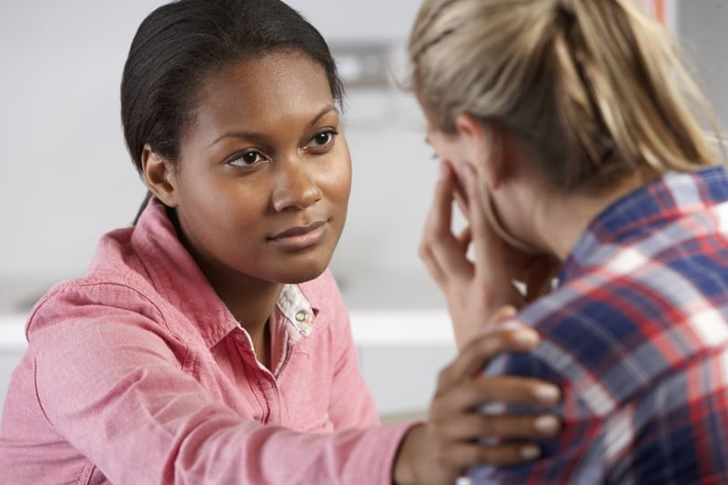 A woman comforting another