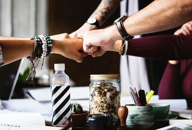 Group fist bumping at an alcohol rehab in Leeds