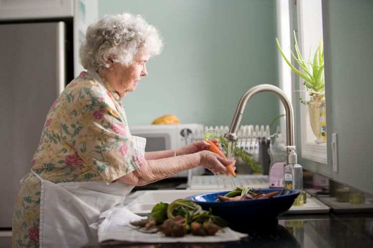 Elderly woman at sink