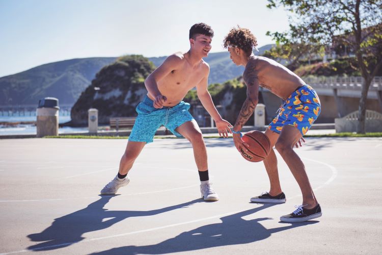 Two young men playing basketball