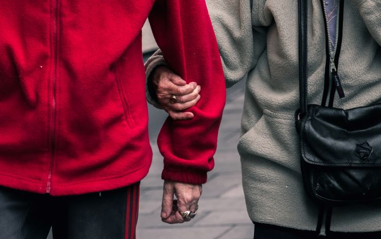 An older couple linking arms