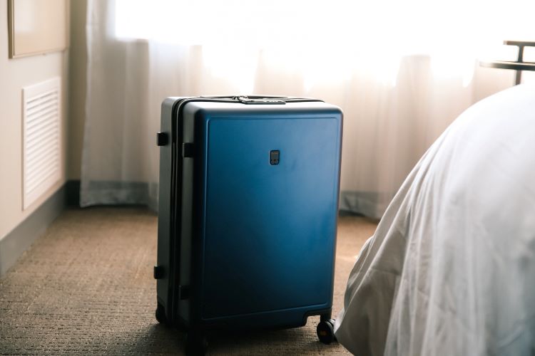 A blue suitcase beside a bed at a rehab in Sheffield