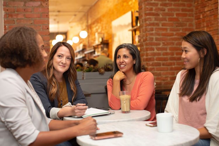 A group conversation between four people at a table