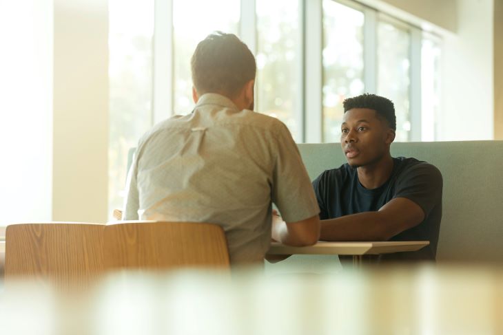 Two people having a serious conversation at a drug and alcohol rehab clinic in Maidstone