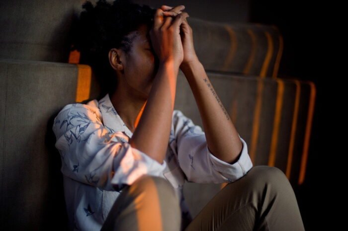 Woman holding her head at a drug and alcohol rehab in Huddersfield