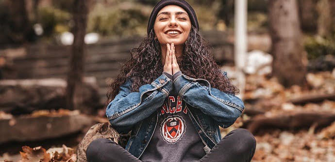A teenager with her hands in prayer