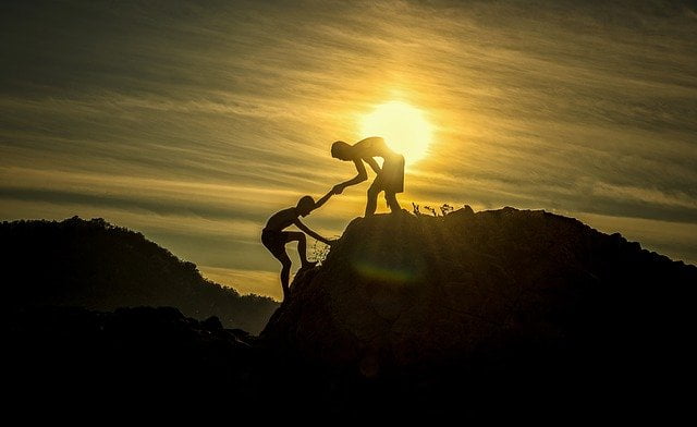 Two people climbing a mountain after rehab in Nottingham