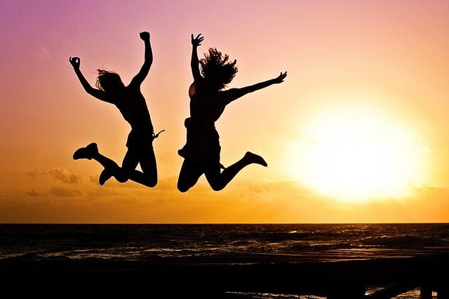 Two people jumping at a sunset in Bedford