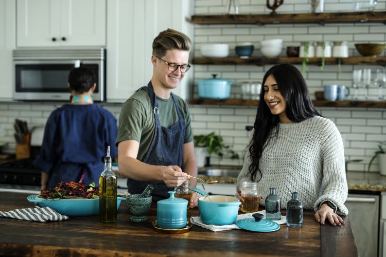 A man and woman cooking in a blue kitchen