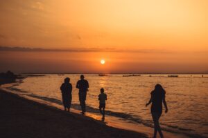Family walking along the beach at sunset