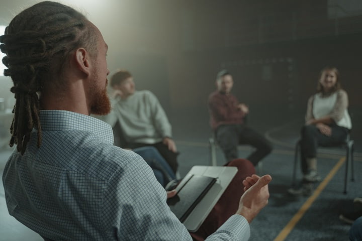 Group therapist taking notes at a drug and alcohol rehab in Hereford