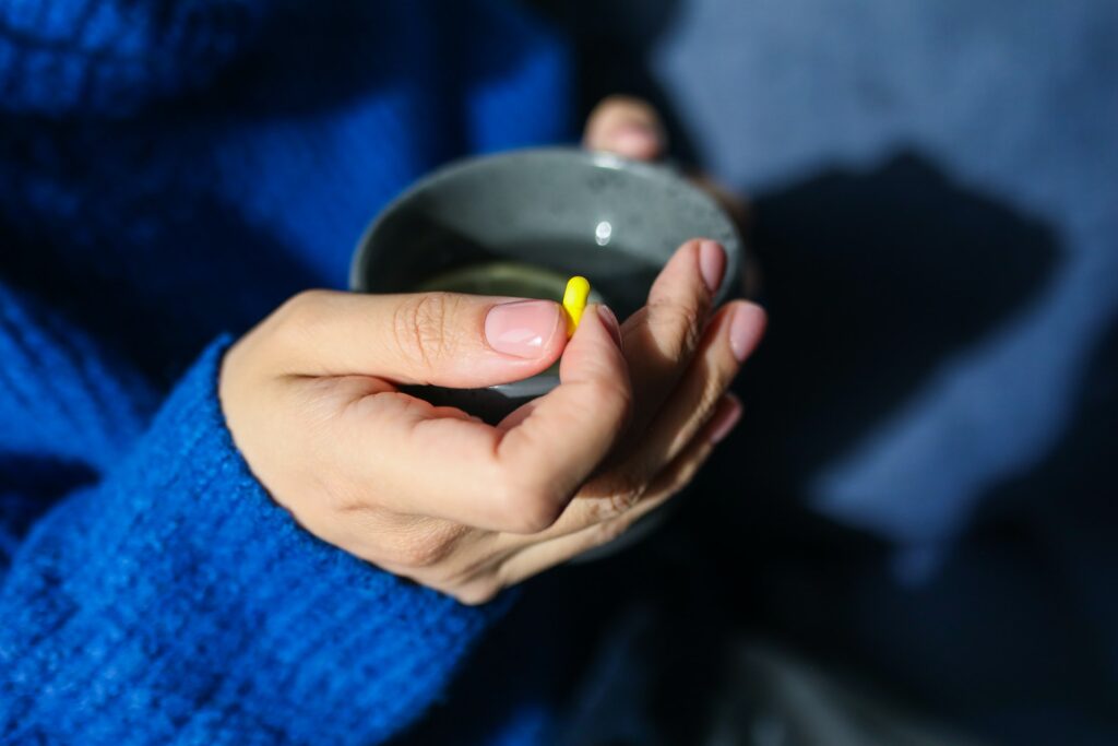 Hand holding pill and cup of tea in Newcastle