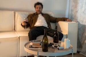 Man sitting on sofa drinking