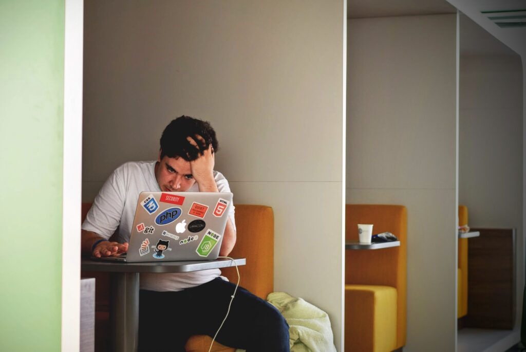 Man working on his laptop looking annoyed