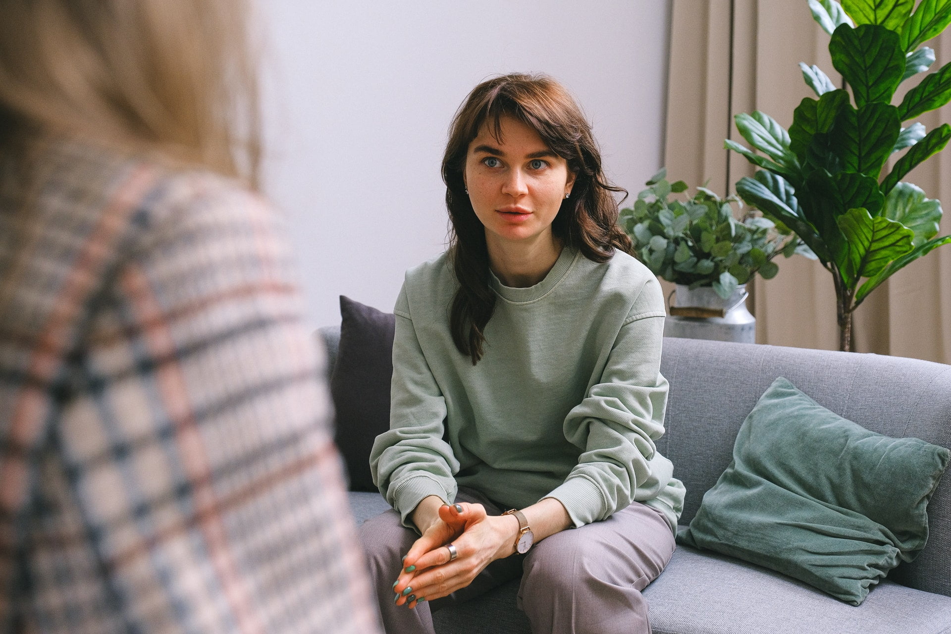 Young woman sitting on a sofa talking to a support worker.