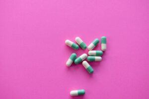 Green pills on a pink background,