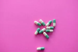 Green pills on a pink background,