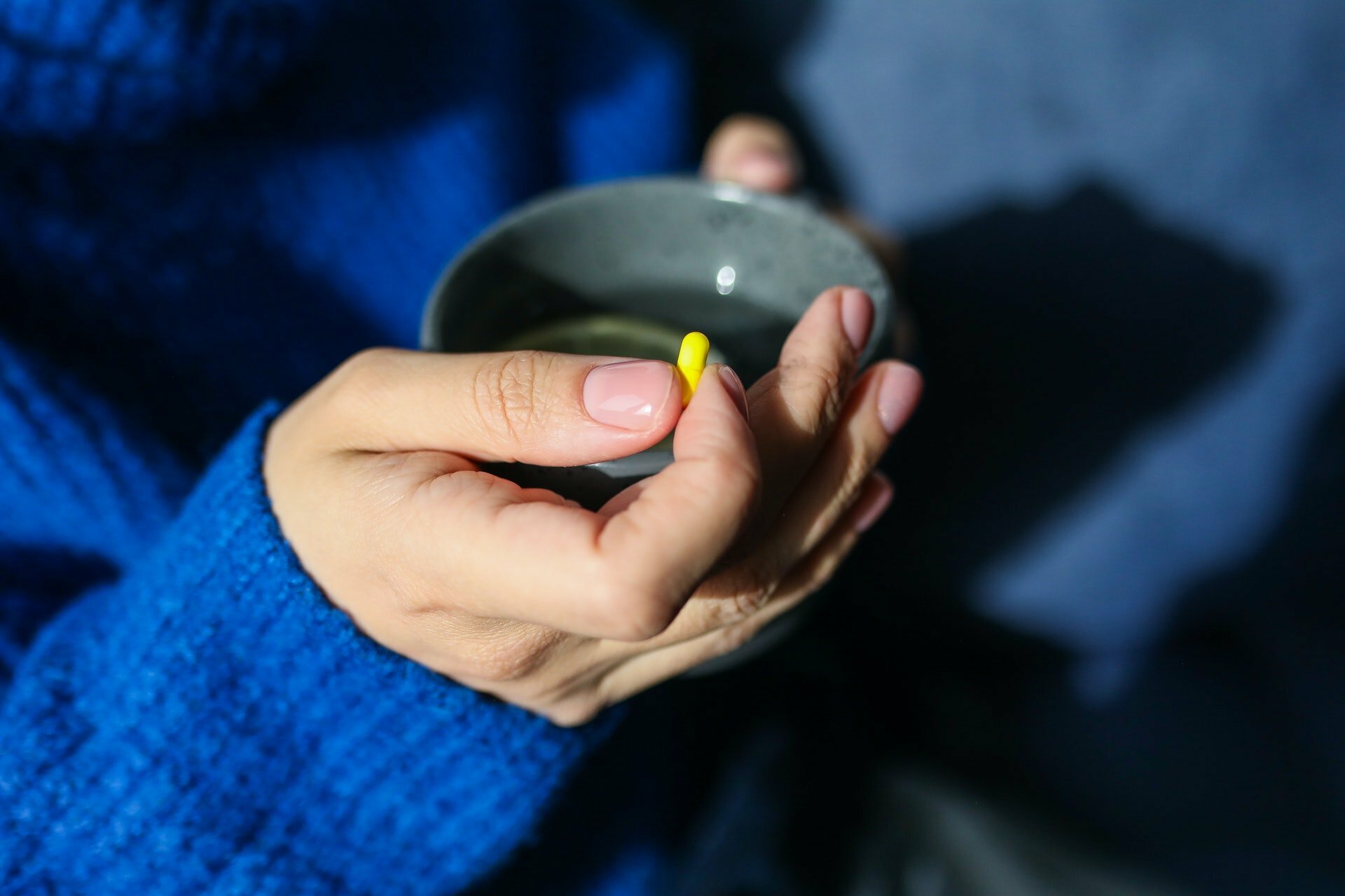 Person taking a pill at a drug and alcohol rehab clinic in East Sussex