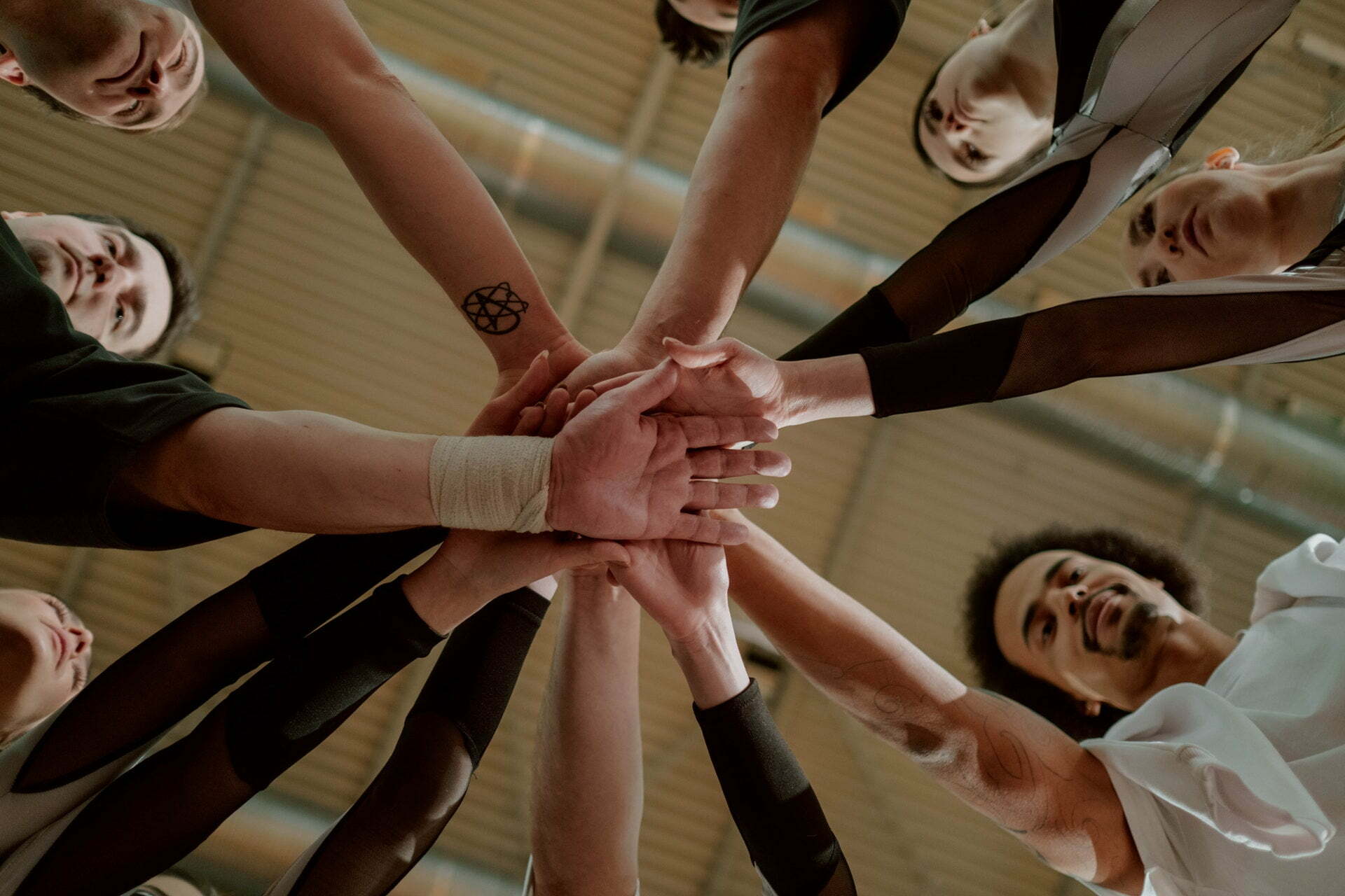 Support group putting their hands together and discussing successful sobriety