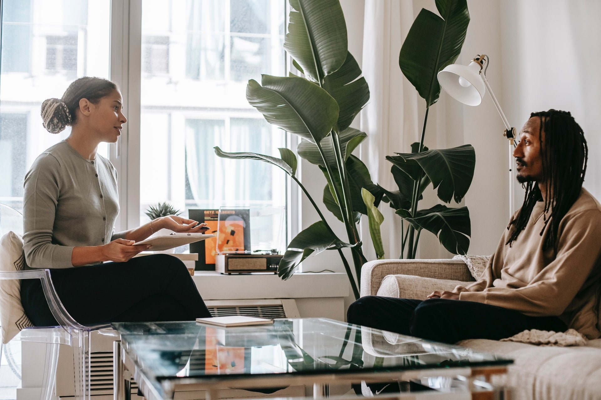 Therapist speaking with a patient and making notes at a drug and alcohol rehab clinic in East Sussex