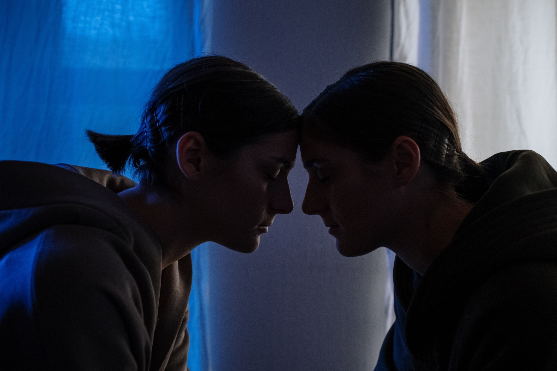 Two people leaning their heads together at a drug and alcohol rehab in East Sussex