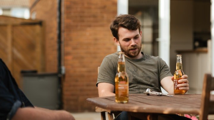 man sat at table with beer