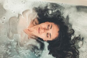 woman with eyes closed in shallow water