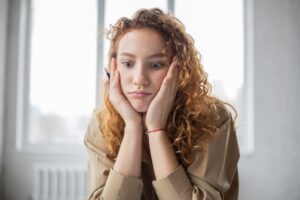 Woman holding her face looking puzzled