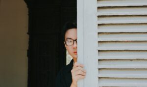 man partially hidden by door