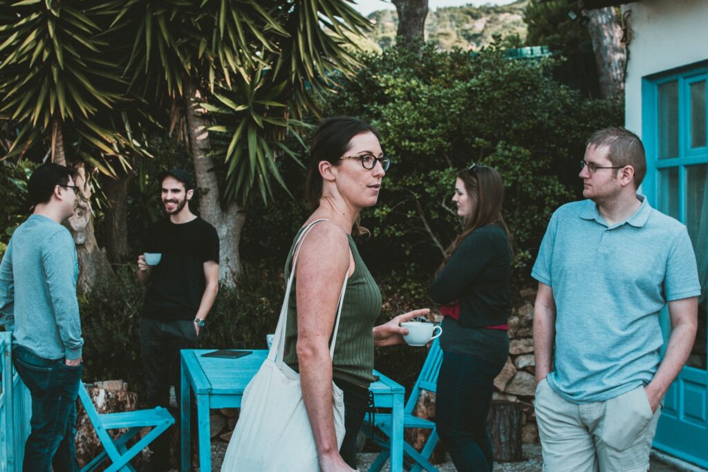 A woman walking through a garden party with an alcoholic drink