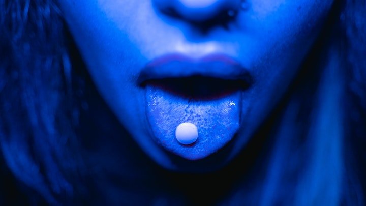 pill on tongue of woman