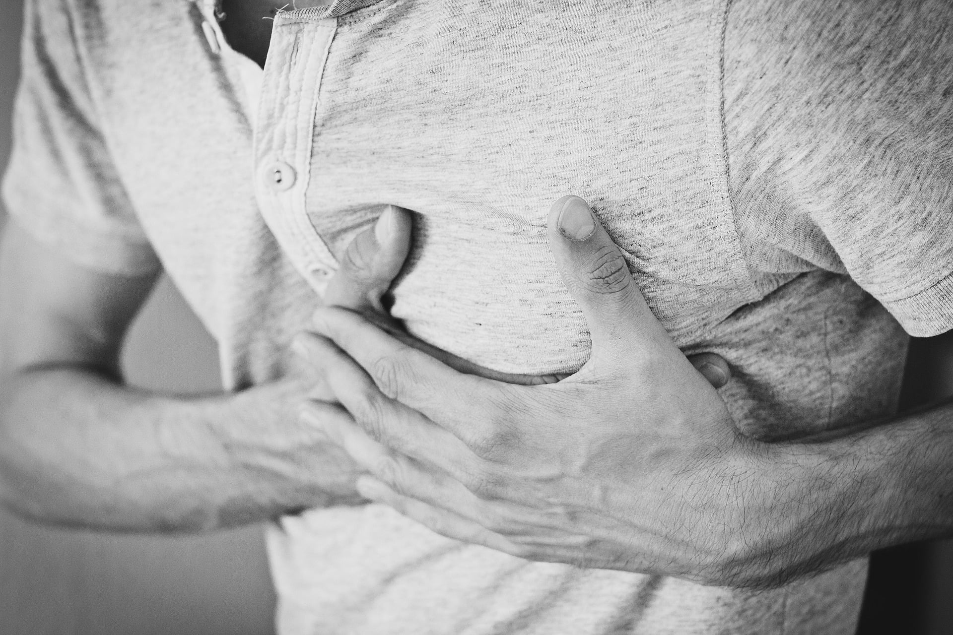 man clutching chest in pain