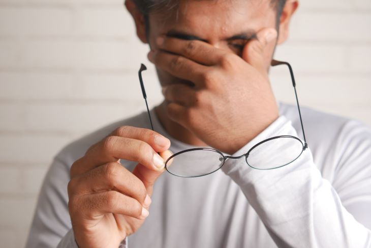 A man in pain, rubbing his eyes in Cumbria or near Cumbria